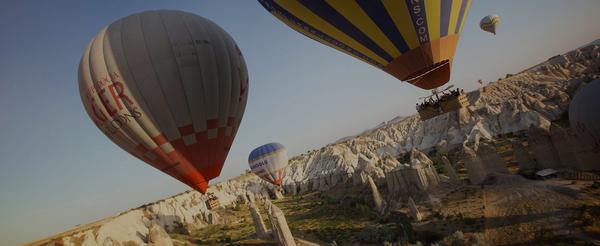 Hot air balloons drifting over mountains