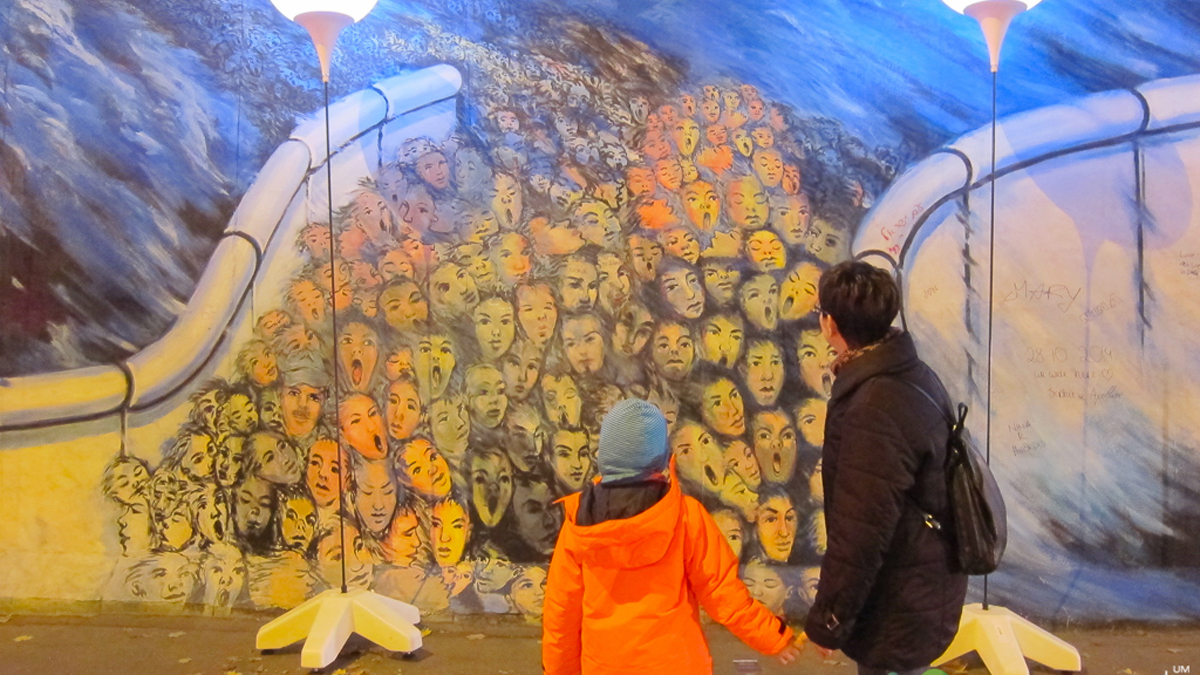 A mother takes her daughter to look at the remnants of the Berlin Wall during the 25th anniversary of its fall.