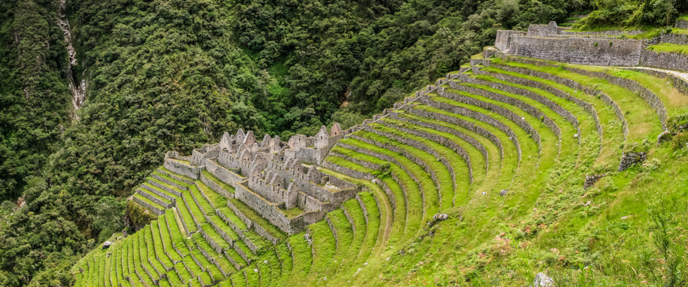 Ruins are built directly into the deep, sloping hills.