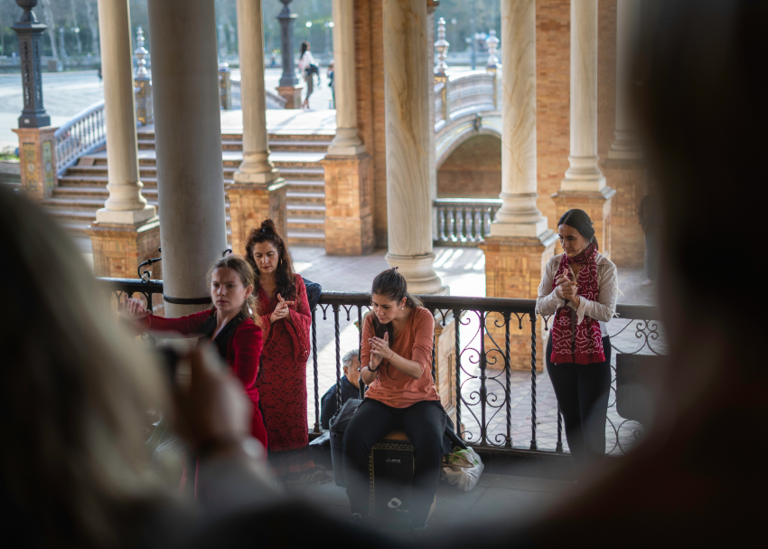 Looking down from a traveller's perspective at an intense live flamenco performance by four women in a town square in Seville, Spain