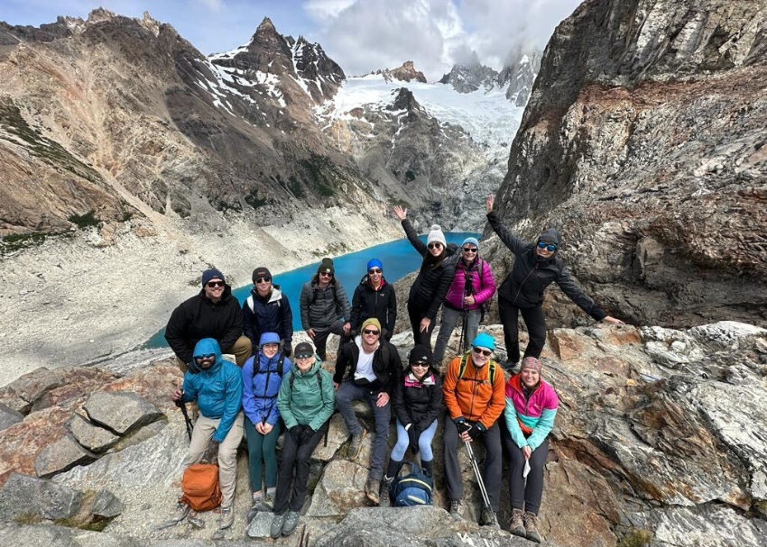 a happy and accomplished bunch of Patagonia trekkers celebrate with a group photo at a blue lagoon